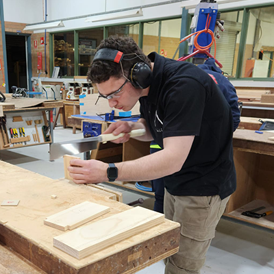 male wearing protective gear working at a workshop