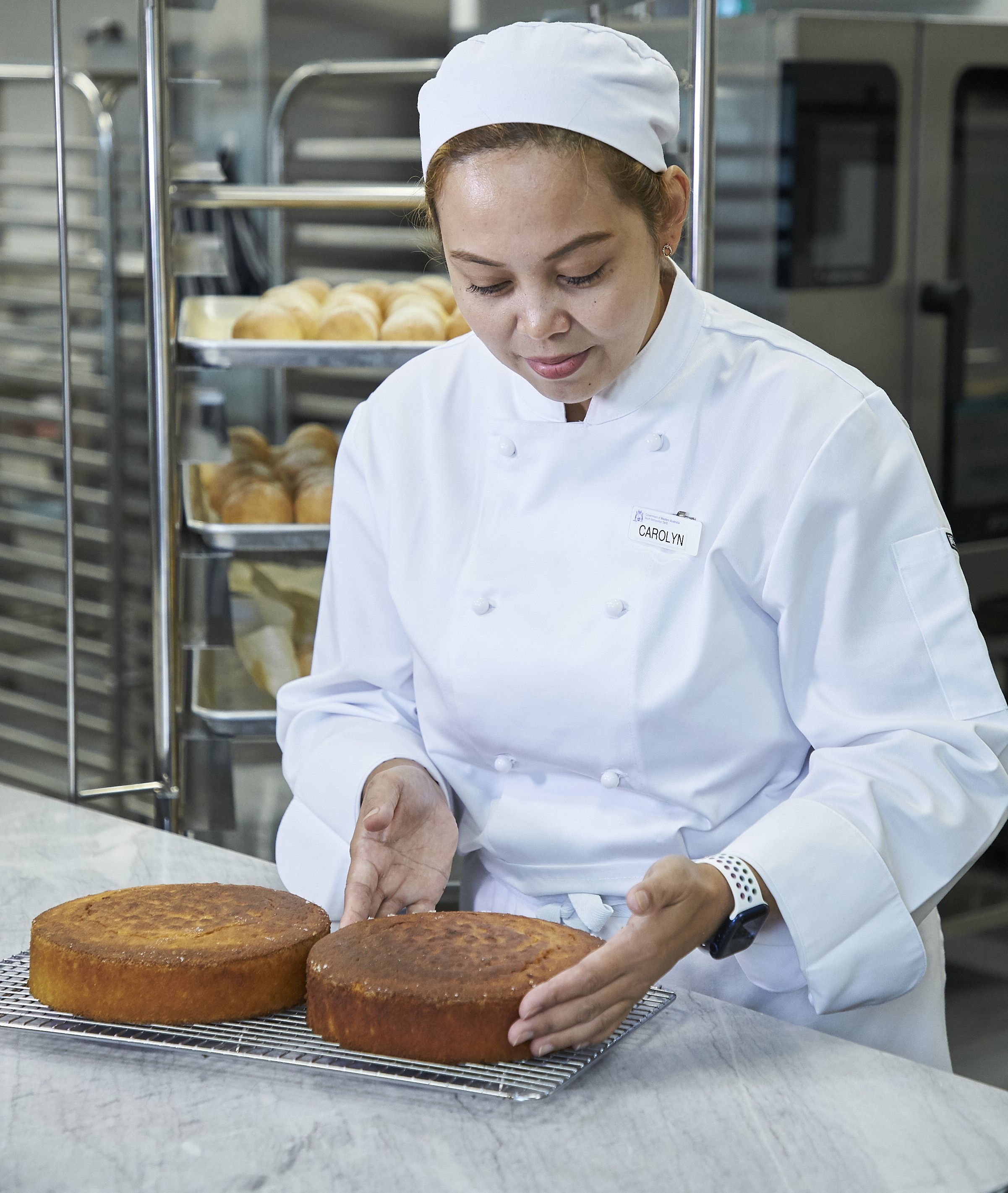 TAFE chef student picking up a cake.