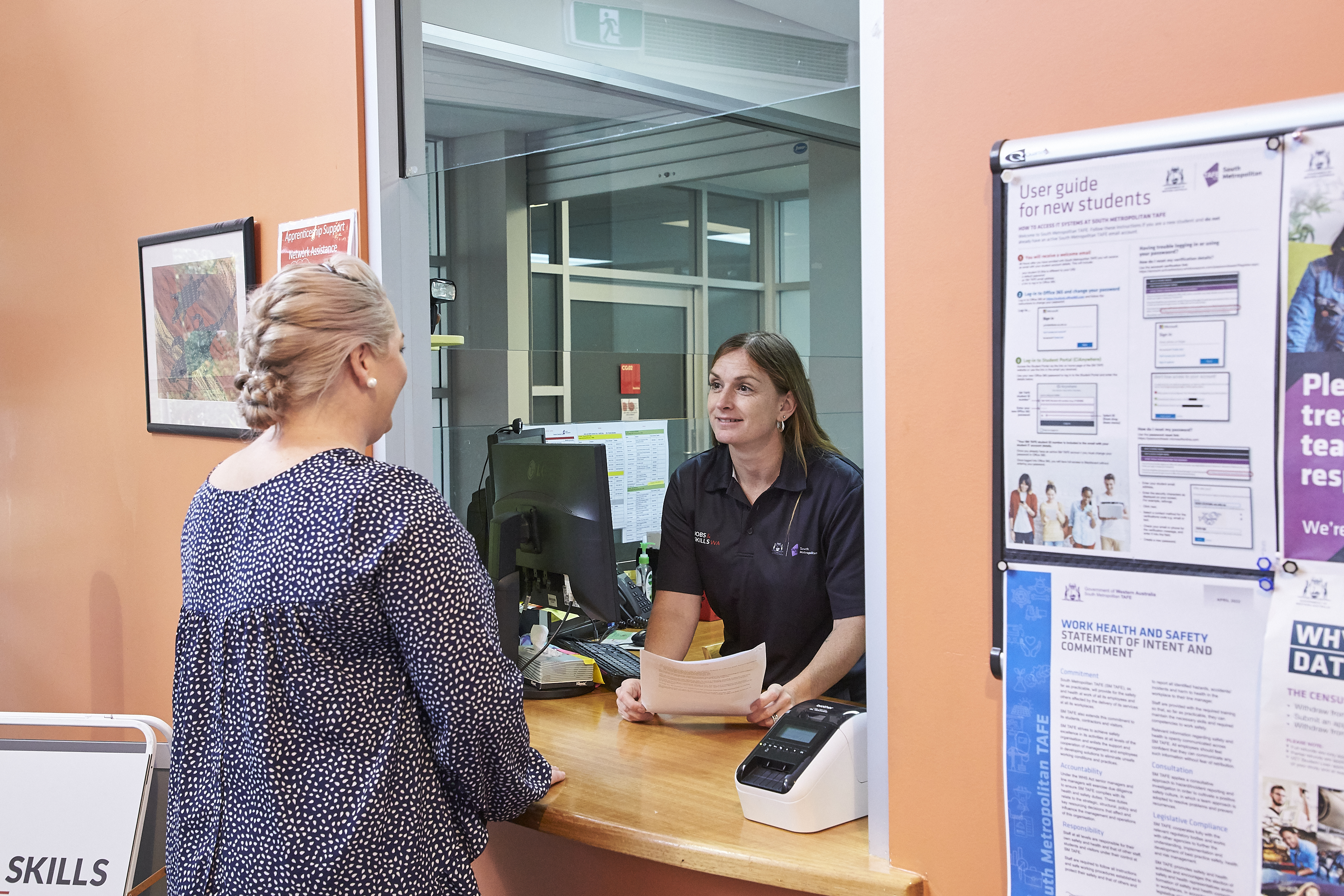 Student standing at JSC counter taking to staff member.