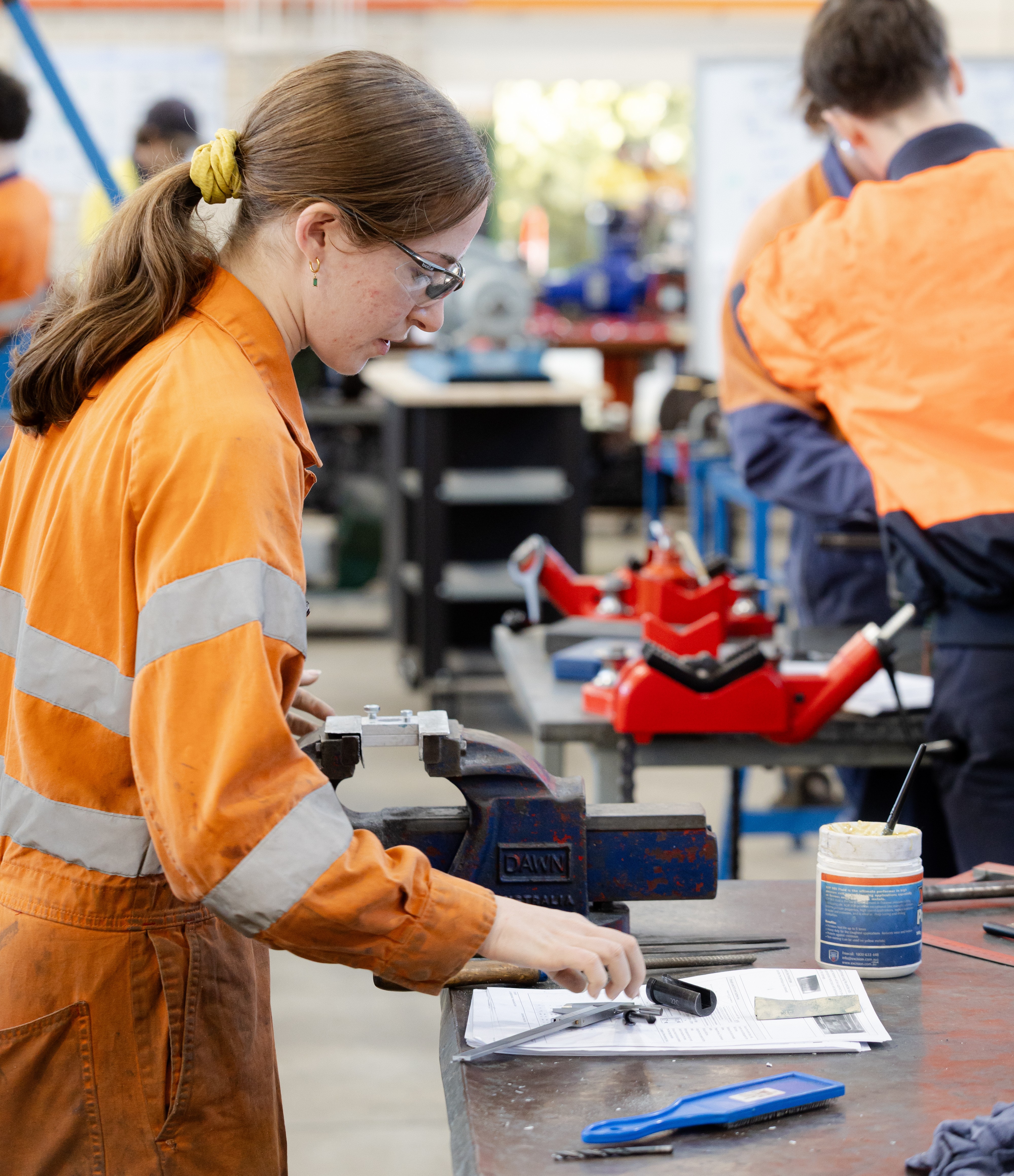 Female fitter and machinist working at table.
