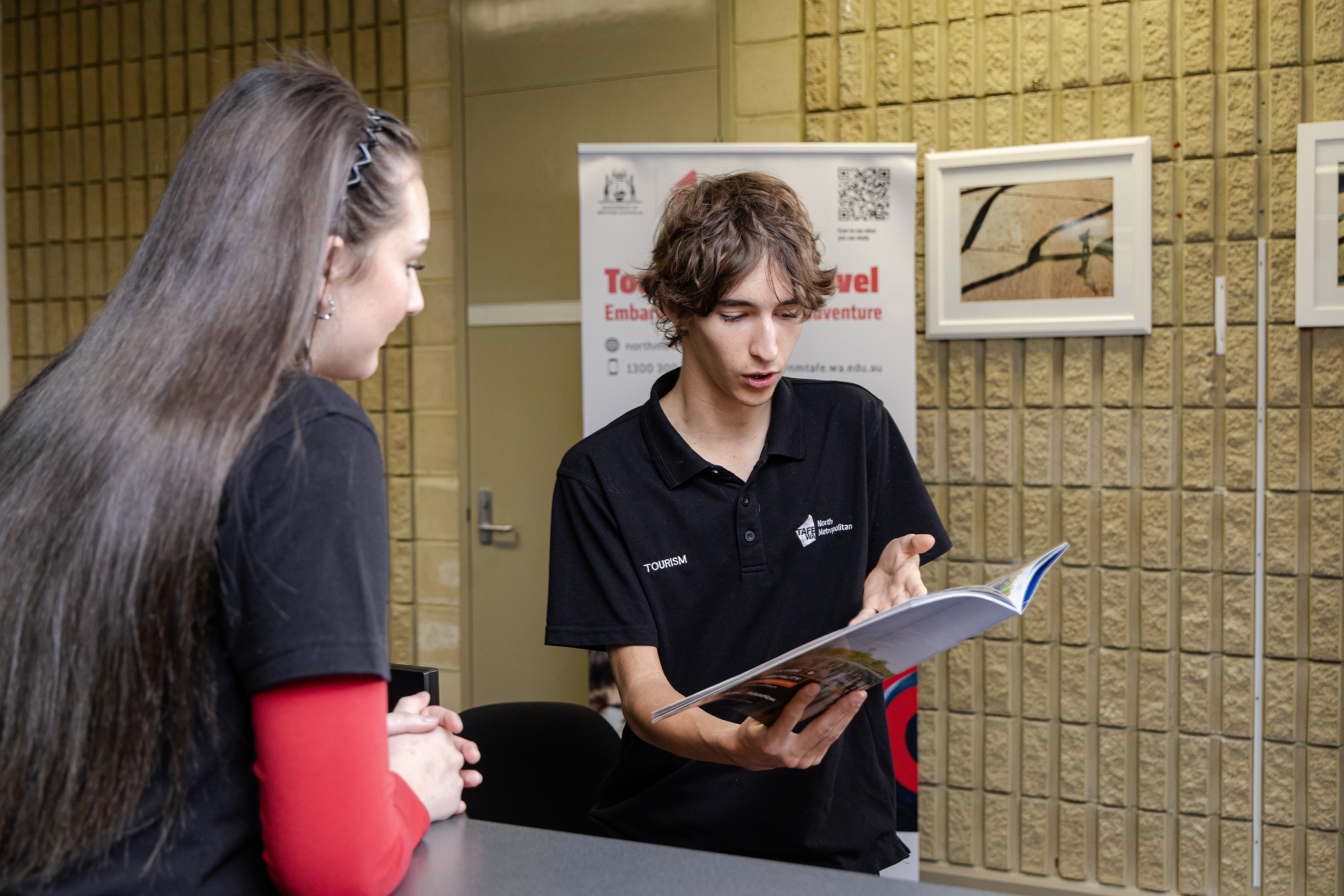 Two students looking at a travel book.