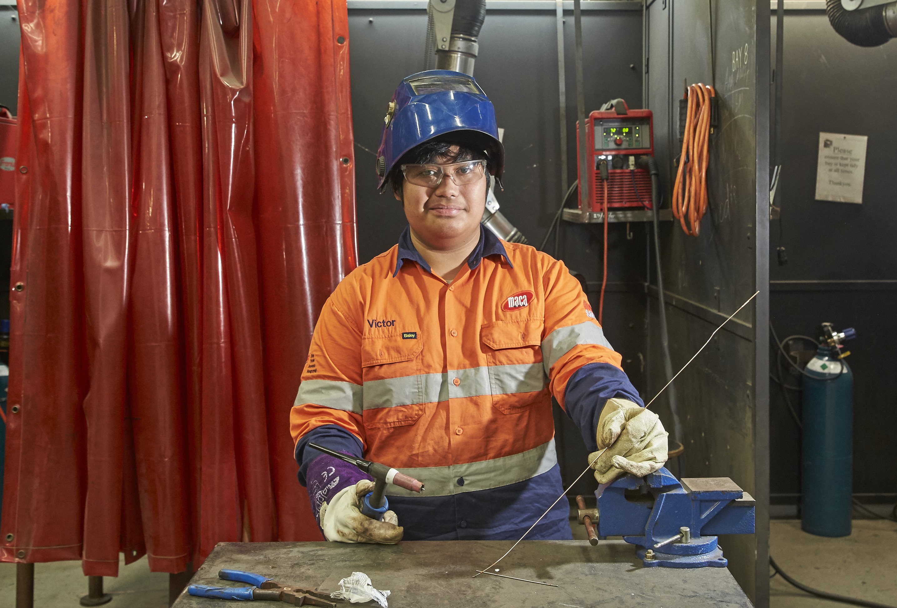 Welding student wearing high vis and helmet.