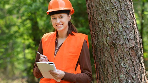 Forest worker leaning on tree