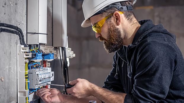 Electrician tinkers with a fuse box