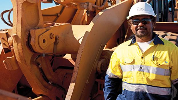 Male stood next to a heavy front loader.