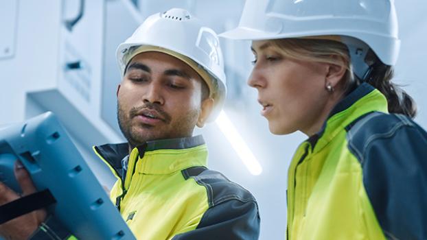 Two maritime workers look over specs on an ipad