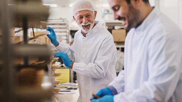 Two men in food processing facility packing food