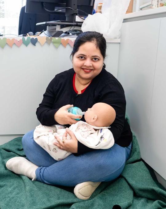 Child care student holding a pretend baby.
