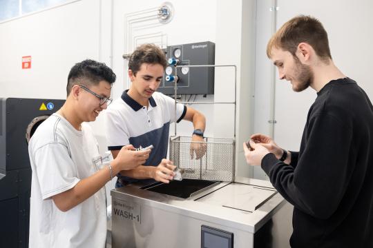 Three engineering students looking at equipment.