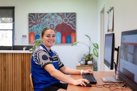 JSC staff member sitting at computer.