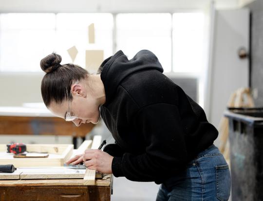 Carpenter measuring wood.