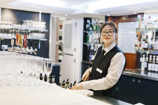Hospitality student preparing drinks.
