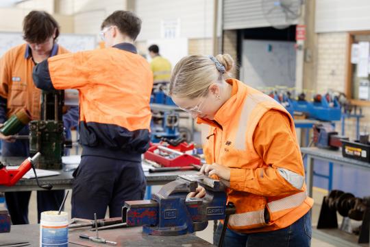 Fitting and machining student using tools.