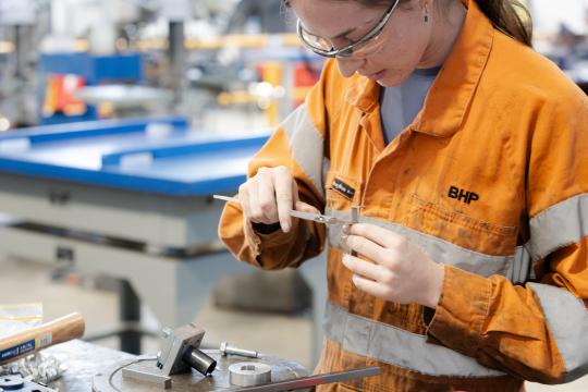 Fitting and machining student using tools.