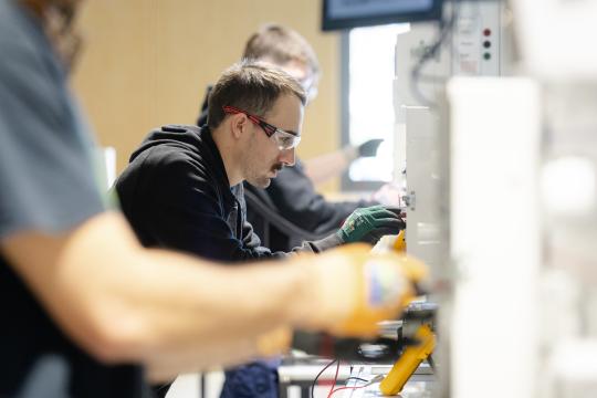 Electrician student working on electrical board.