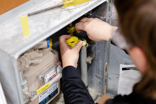 Plumbing student doing technical work with hands.